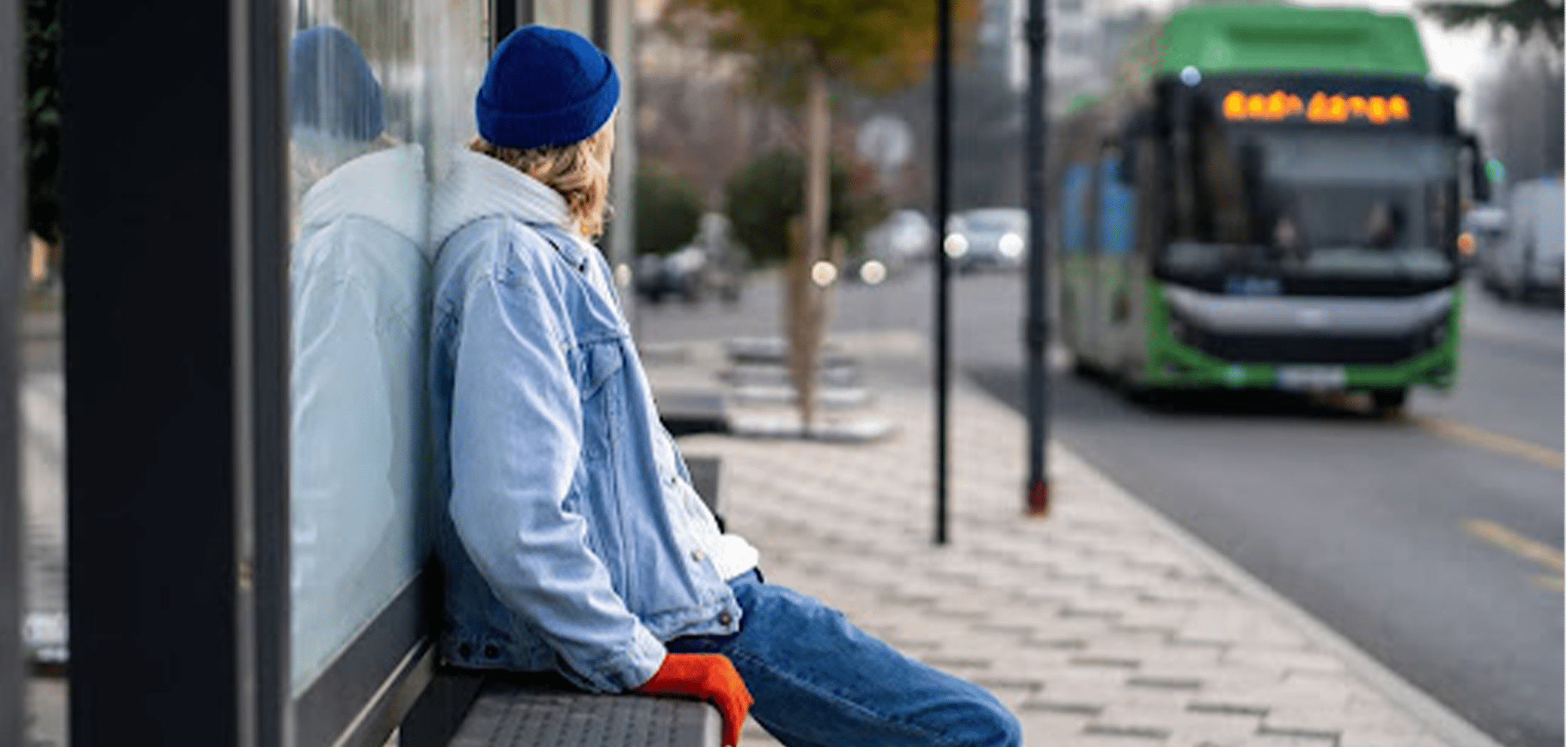 Woman standing on sidewalk and waiting for a bus