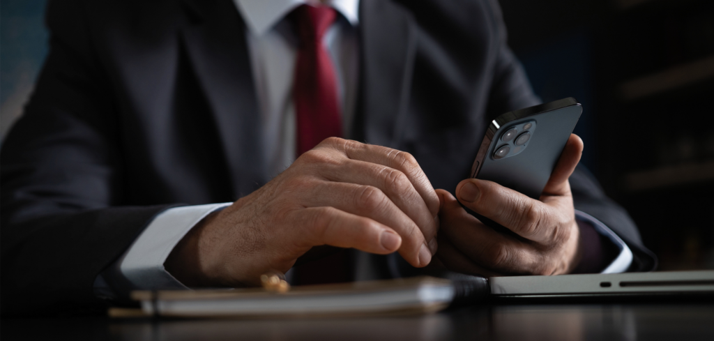 Businessman in a suit typing a message on his phone
