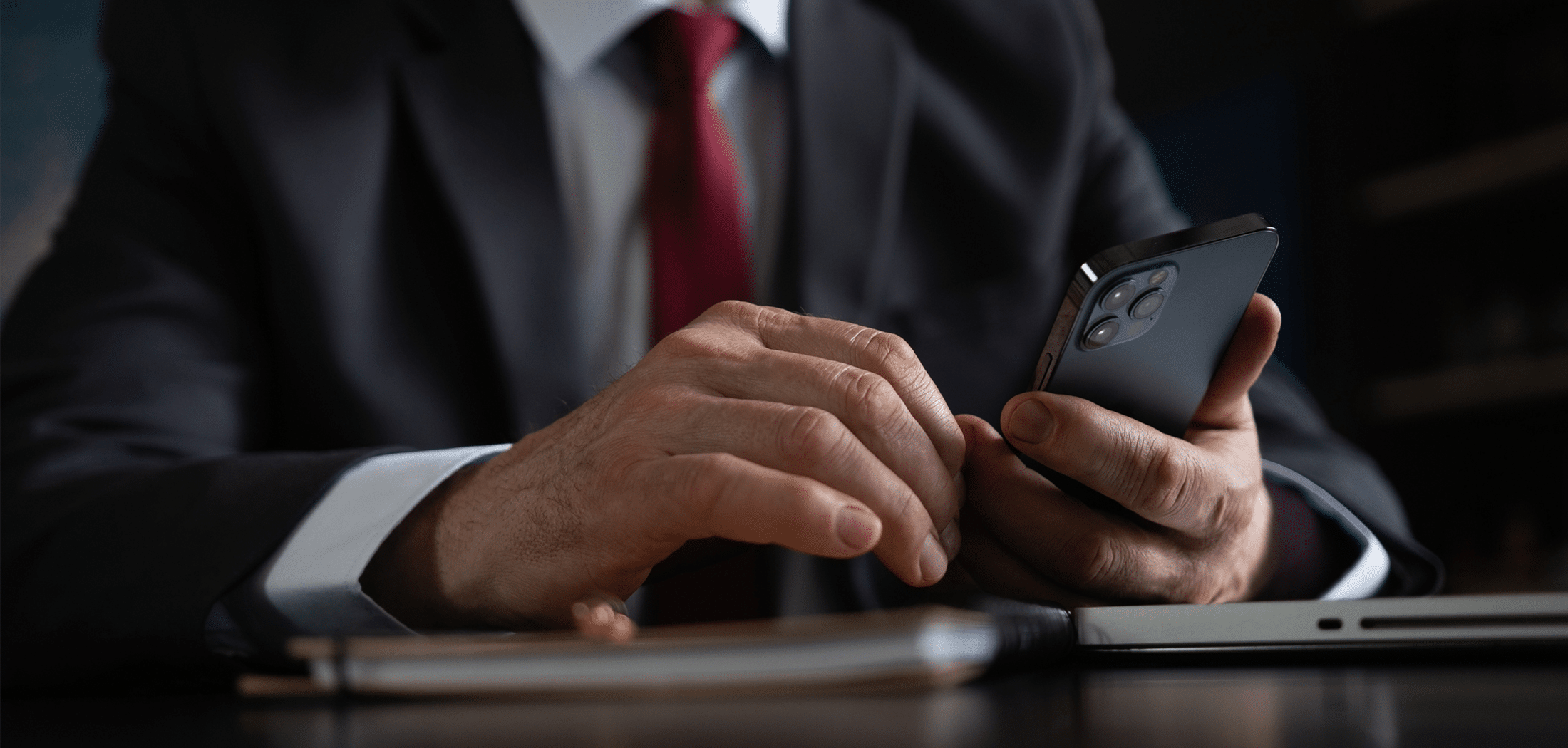 Businessman in a suit typing a message on his phone