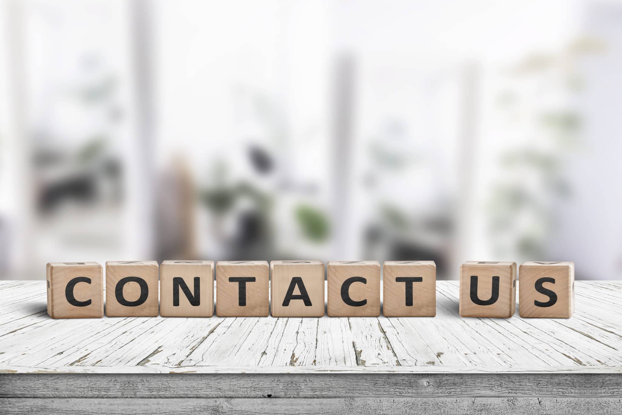 Contact us sign on a wooden desk