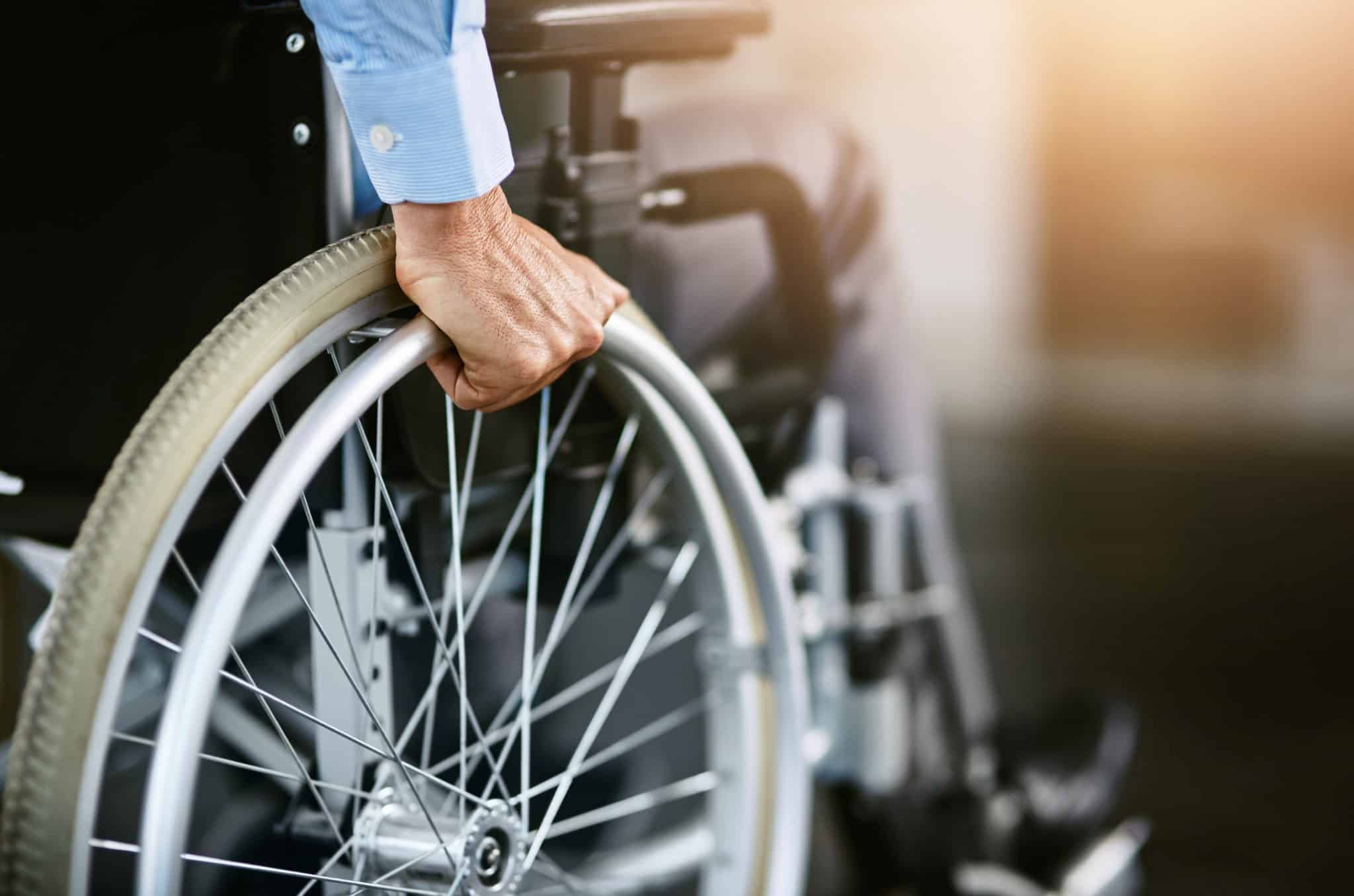 Wheelchair user's hand on wheel
