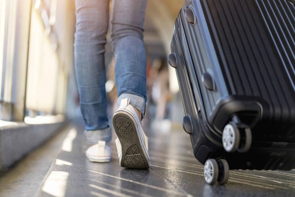 Feet next to luggage being pulled along