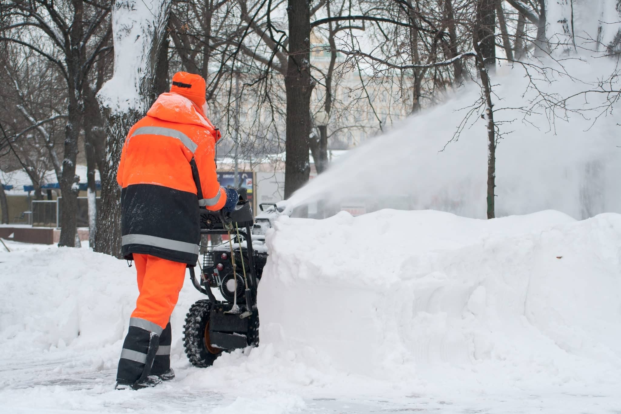 Snow blower being used by person in high vis
