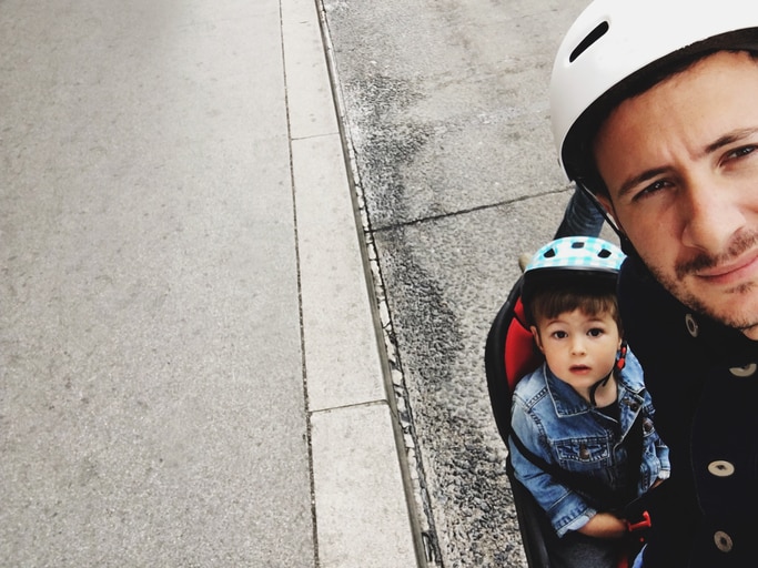 Father and his son making a selfie while cycling together outdoors on a beautiful day