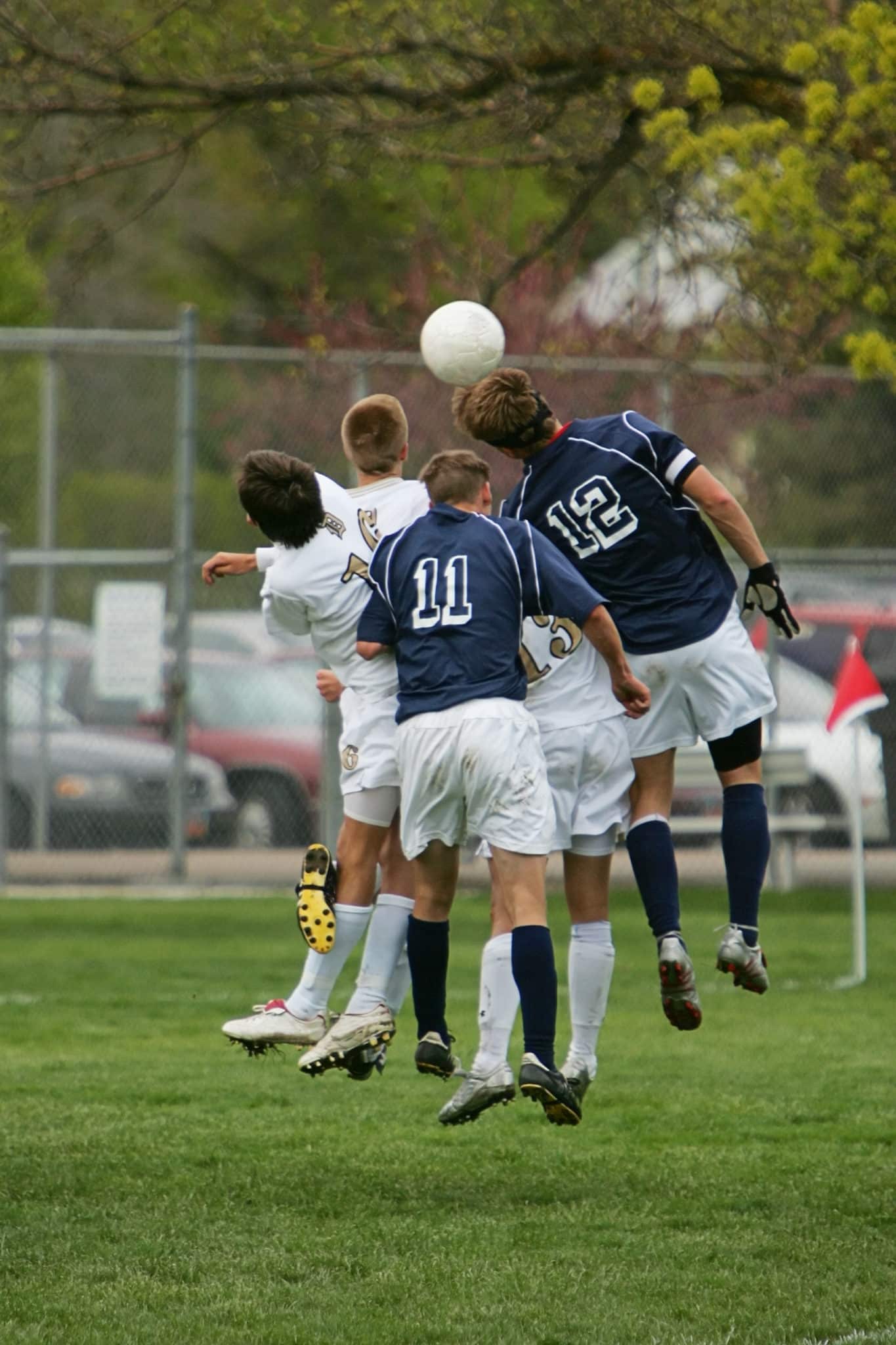 soccer players jumping for ball